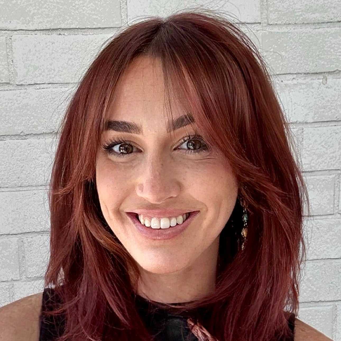 Portrait of Tess, a professional stylist at Hudson Salon, showcasing their expertise and style.